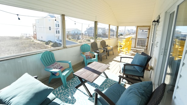 A covered outdoor area with seating and a view of the beach. - Perfect for Couples and Families - Amazing Ocean View Beach House (North Topsail Beach)