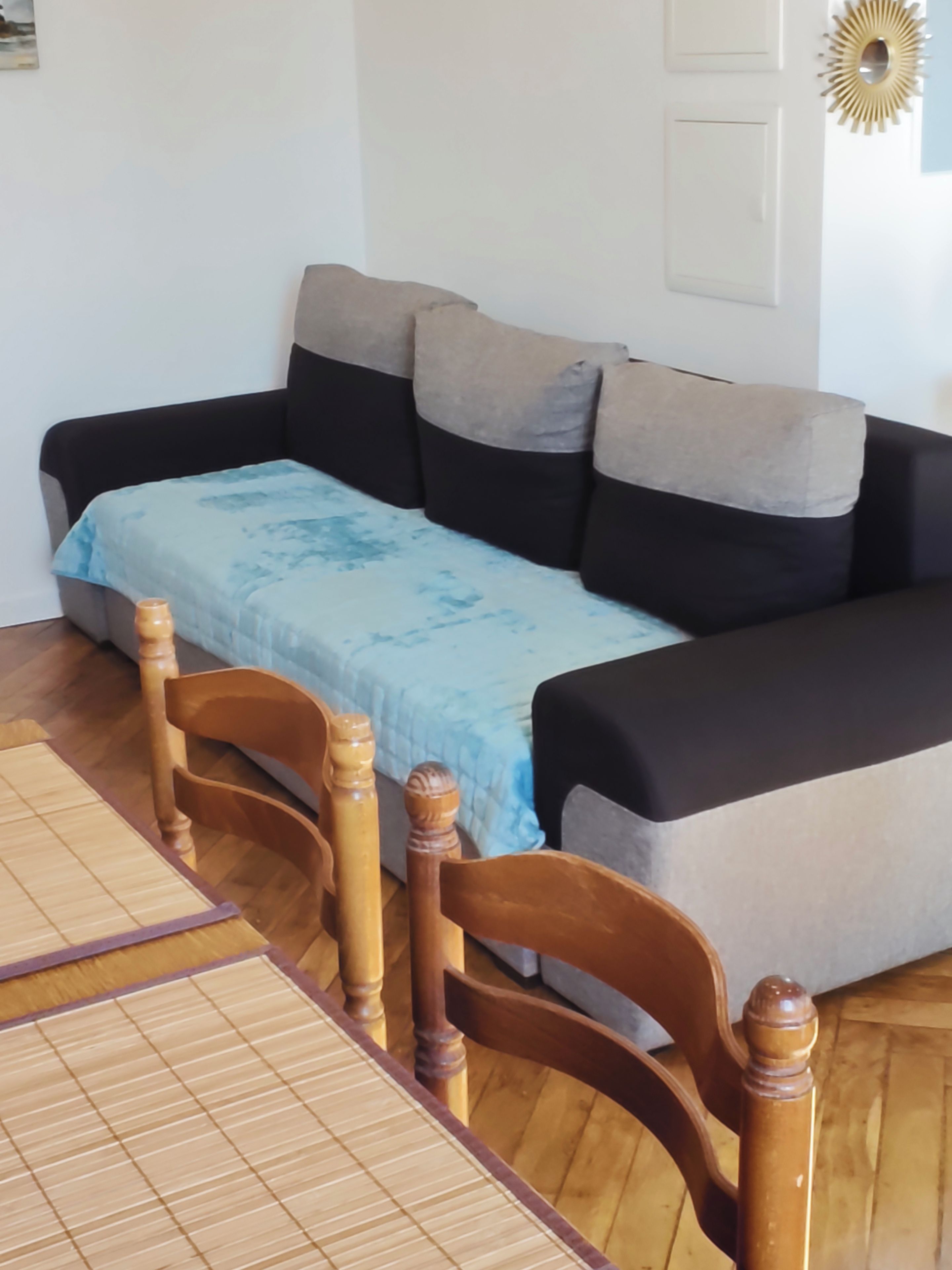 A room with a sofa, a wooden table, and a patterned rug.