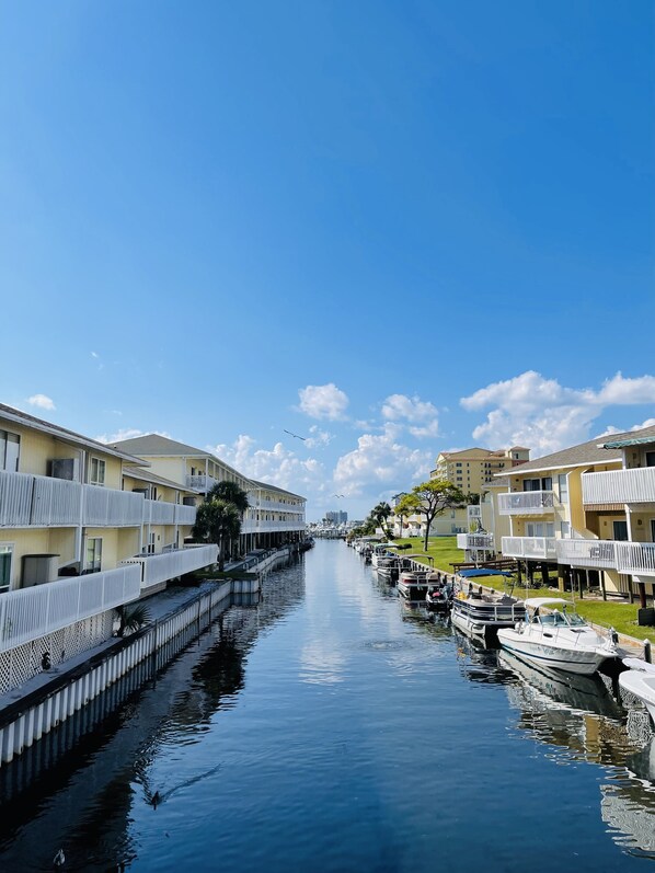 A canal with boats docked on both sides, flanked by multi-story buildings with balconies.