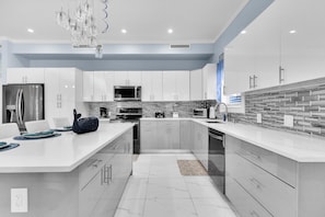 Enjoy cooking and entertaining in this stylish kitchen with a spacious island, sleek cabinetry, and modern appliances.