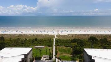 Vista di una spiaggia con un parcheggio e degli edifici in primo piano.