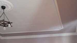 A bedroom with a bed, a nightstand, a wardrobe, and a ceiling light fixture.