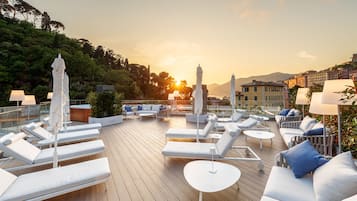 Relax on the rooftop terrace with serene views of the hillside and coastal town.