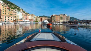 A marina with boats docked, surrounded by colorful buildings and a clear sky. - Carrick Hotel Camogli Portofino Coast (Camogli)
