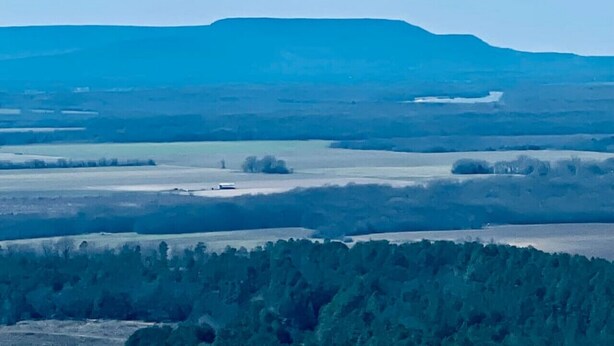 A flat landscape with a prominent hill in the background and a dense forest in the foreground. - Nebo’s Foot, Hike&Bike Cabin Escape at Mt. Nebo (Dardanelle)