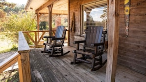A wooden porch with two rocking chairs and a wooden railing. - Nebo’s Foot, Hike&Bike Cabin Escape at Mt. Nebo (Dardanelle)