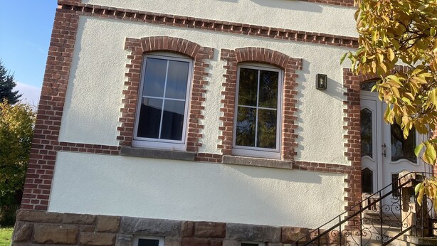 Un bâtiment à deux étages, doté d’une façade en briques, de nombreuses fenêtres et d’une cheminée.
