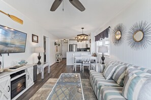 Condo com design assinado, 2 quartos, sacada, vista para a praia | Área de estar | TV de tela plana