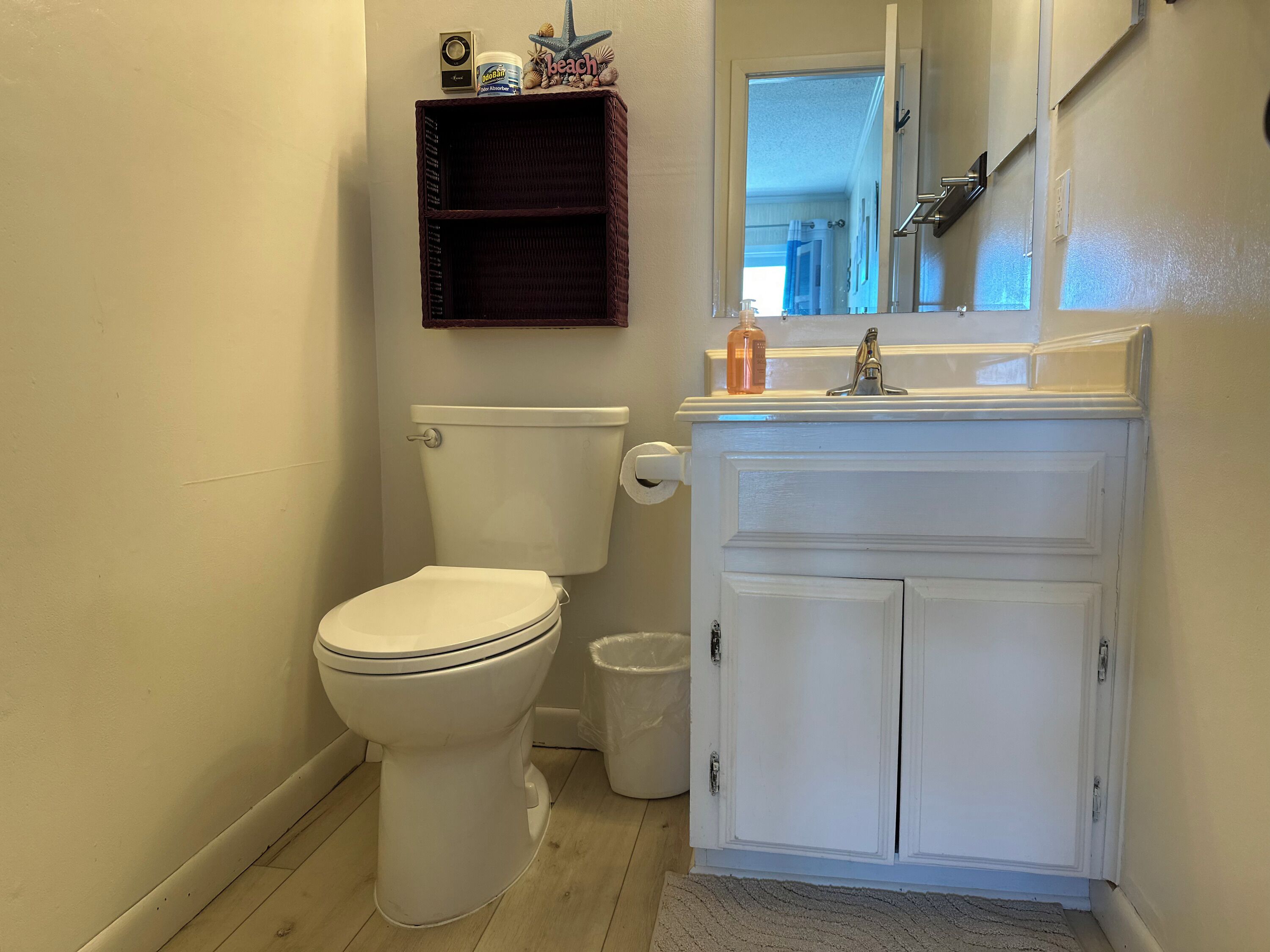 A bathroom with a toilet, a sink, and a mirror.