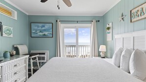 Ein Schlafzimmer mit einem großen Bett, einem Deckenventilator, Blick auf den Strand und einem Schild mit der Aufschrift 'BEACH'.