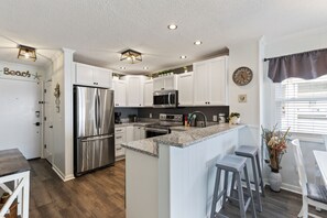 Condo com design assinado, 2 quartos, sacada, vista para a praia | Cozinha privada | Geladeira, micro-ondas, fogão, cooktop