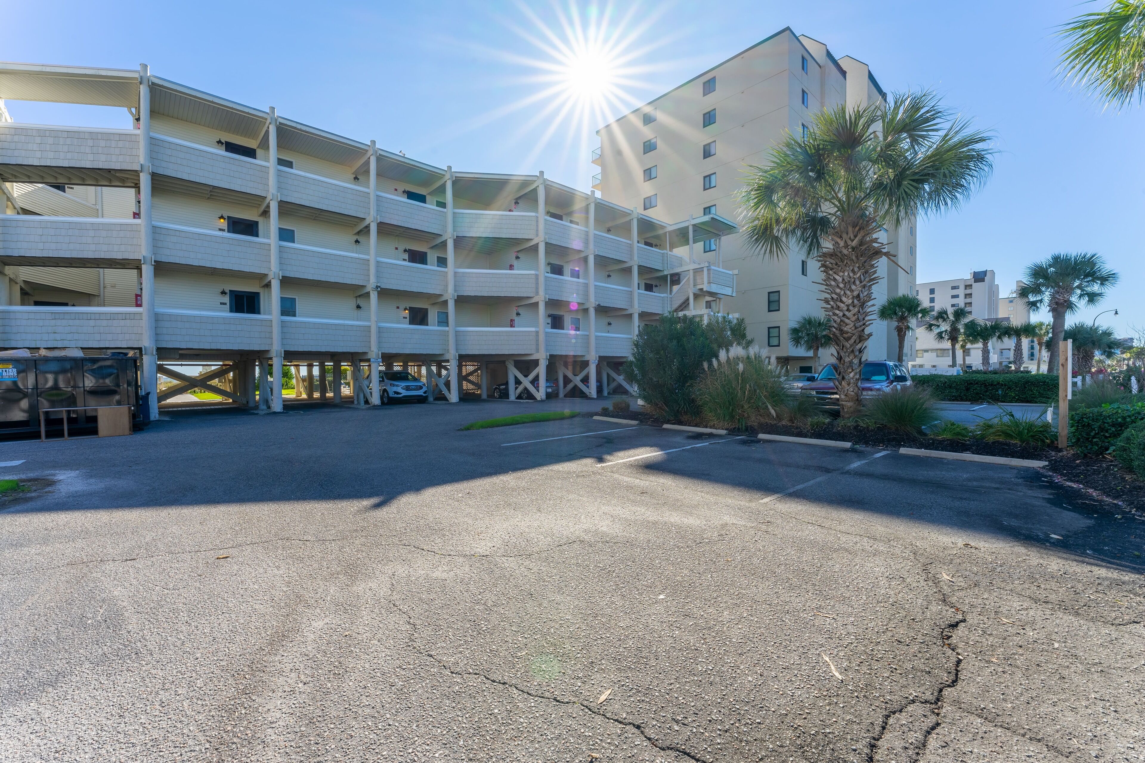 A multi-story parking garage with a clear sky and sun shining.