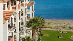 A multi-story hotel with balconies overlooking a beach and the sea. - Ocean View Condo at Pool-Beach and Golf Resort with Concierge, Maids and Chef - Meal Services (La Paz)