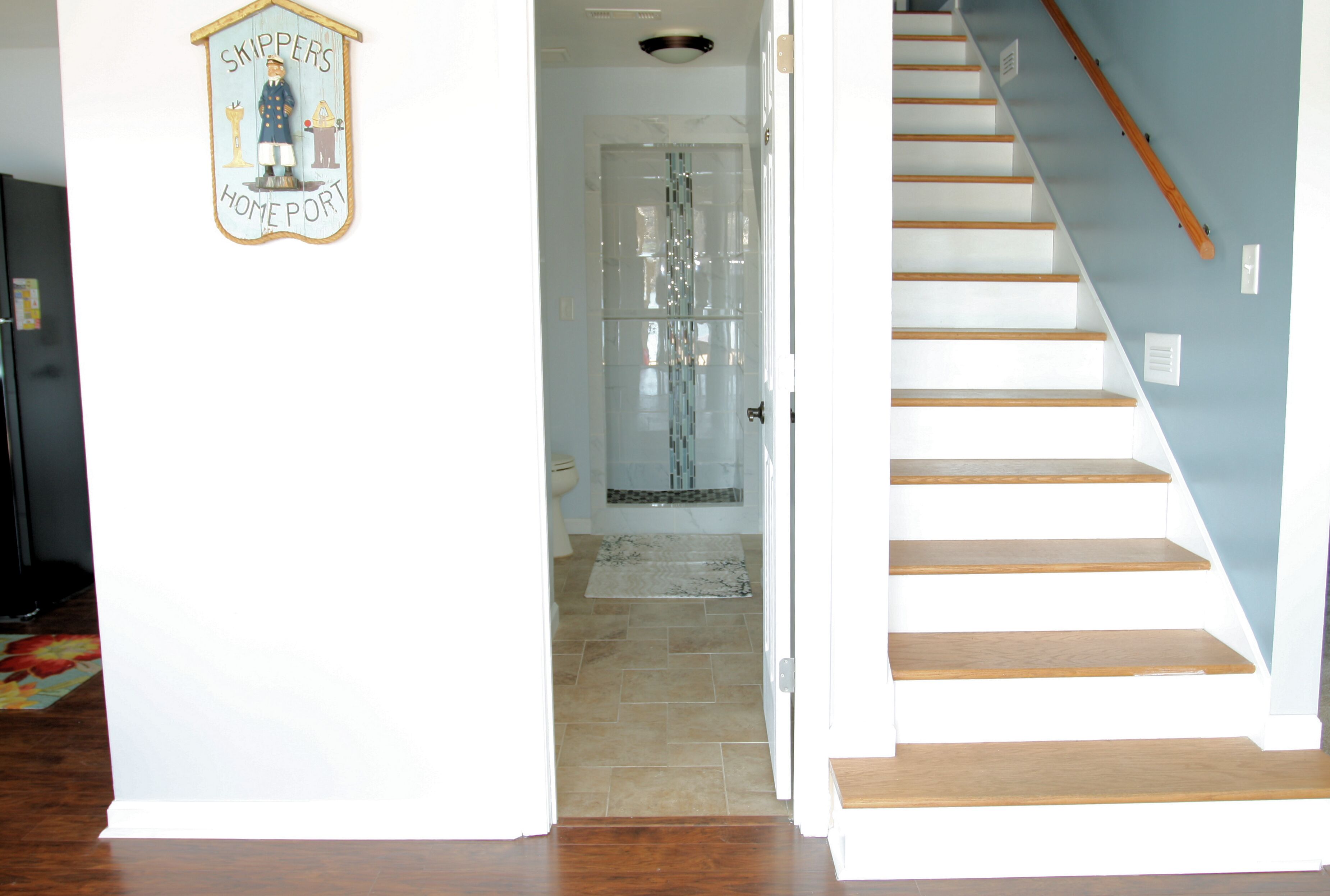 A staircase leading to a bathroom with a glass shower enclosure.