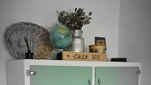 A green and white cabinet with multiple drawers and doors, topped with decorative items including a globe and a basket. - RURAL ENVIRONMENT, land of fields and vineyards.GORDONCILLO (Gordoncillo)