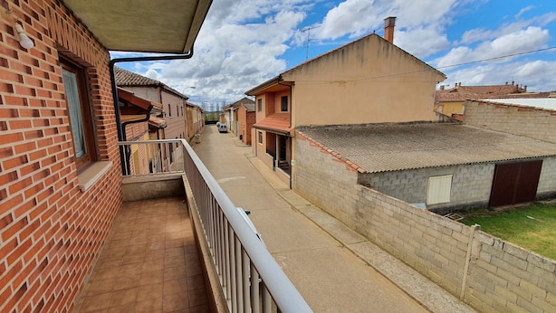 A narrow street with brick houses, a balcony, and a clear sky. - RURAL ENVIRONMENT, land of fields and vineyards.GORDONCILLO (Gordoncillo)