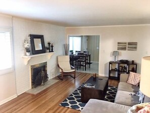 Cozy living room with a fireplace, sofa, and dining area.