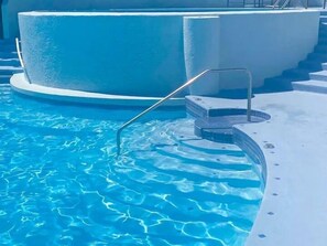 Ein Schwimmbad mit klarem, blauem Wasser und einem Sprungbrett.