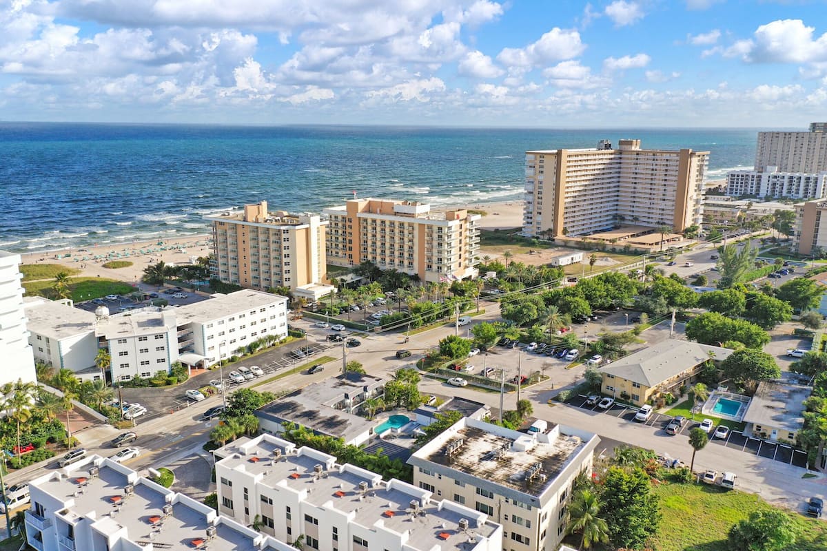 Un paisaje urbano costero con hoteles de gran altura, una playa y un estacionamiento.