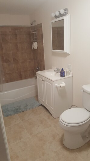 Une salle de bain avec une baignoire, un lavabo, des toilettes et un miroir.