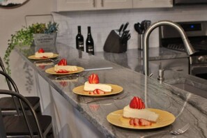 A kitchen counter with a marble surface, a sink, and a knife block. - Fieldview | A Spacious Stay Near WWU & Downtown (College Place)