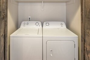 Een wasserette met twee witte wasmachines en een droger.