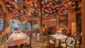 A dining area with a long table set for a meal, surrounded by chairs. - Hotel Plaza del Fuerte by Balderrama Hotel Collection  (El Fuerte)