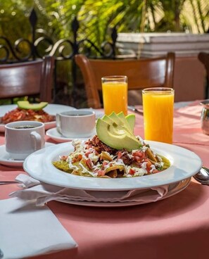 A table set with a plate of food, a glass of orange juice, and a cup of coffee.