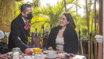 Una mesa de comedor dispuesta con platos, tazas y cubiertos.