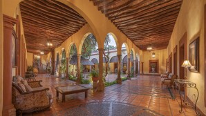 A spacious courtyard with tiled flooring, a central seating area, and arches. - Hotel Plaza del Fuerte by Balderrama Hotel Collection  (El Fuerte)