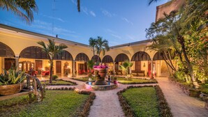 A courtyard with a central fountain, surrounded by palm trees and a pathway. - Hotel Plaza del Fuerte by Balderrama Hotel Collection  (El Fuerte)