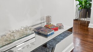 Ein Tisch mit Glasplatte, Büchern, einer Kristallschale und Dekorationselementen.