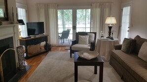 A living room with a fireplace, a television, a sofa, a chair, and a table with a candle. - Book with an owner not a management company-personalized service! Great reviews (Pawleys Island)
