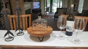 A dining table with a wine bottle, two glasses, and a decorative centerpiece. - Book with an owner not a management company-personalized service! Great reviews (Pawleys Island)
