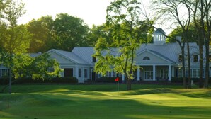 A golf course with a clubhouse featuring a covered porch and a flag on the green. - Book with an owner not a management company-personalized service! Great reviews (Pawleys Island)