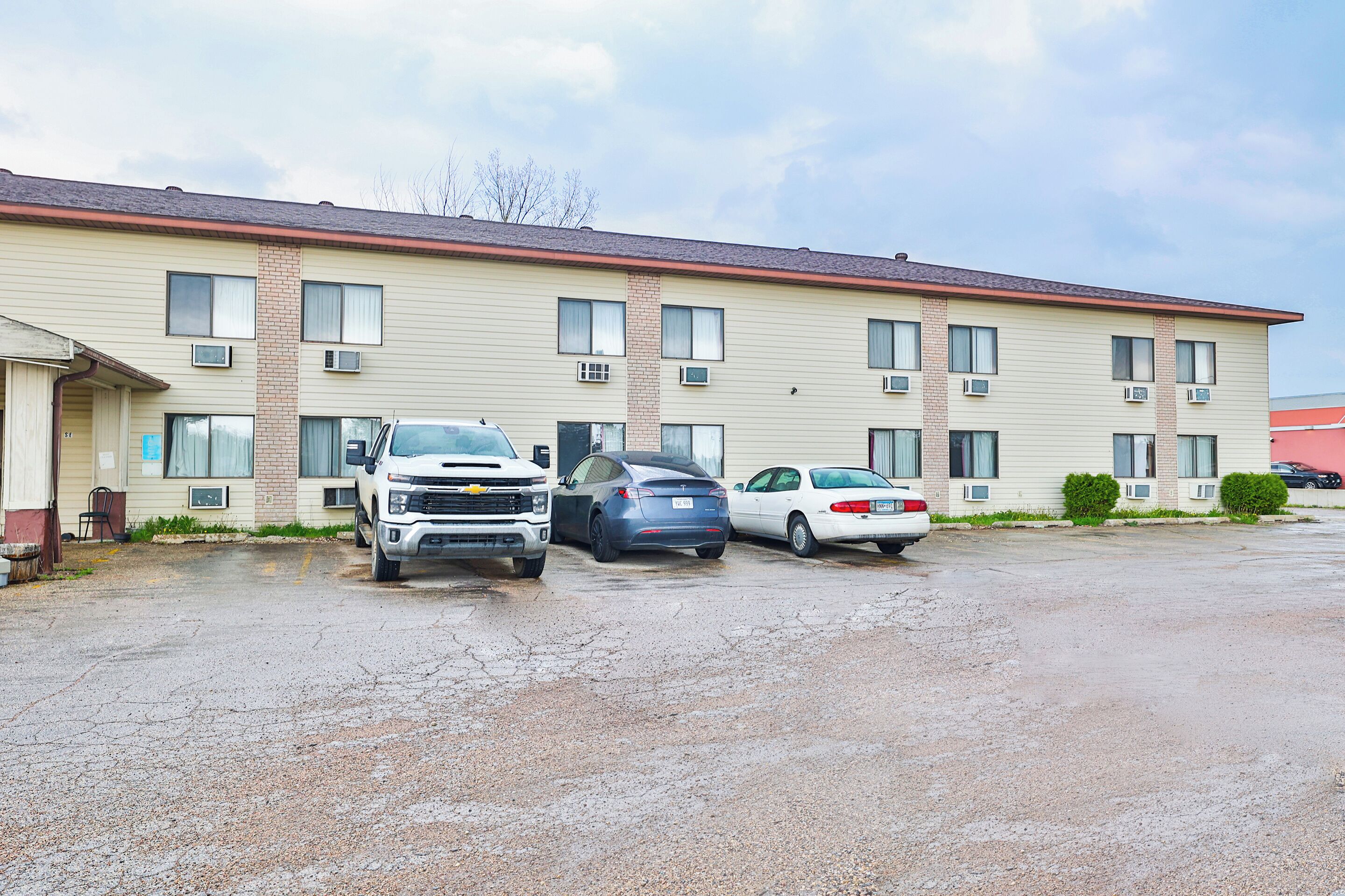 Un motel de varios pisos con estacionamiento.