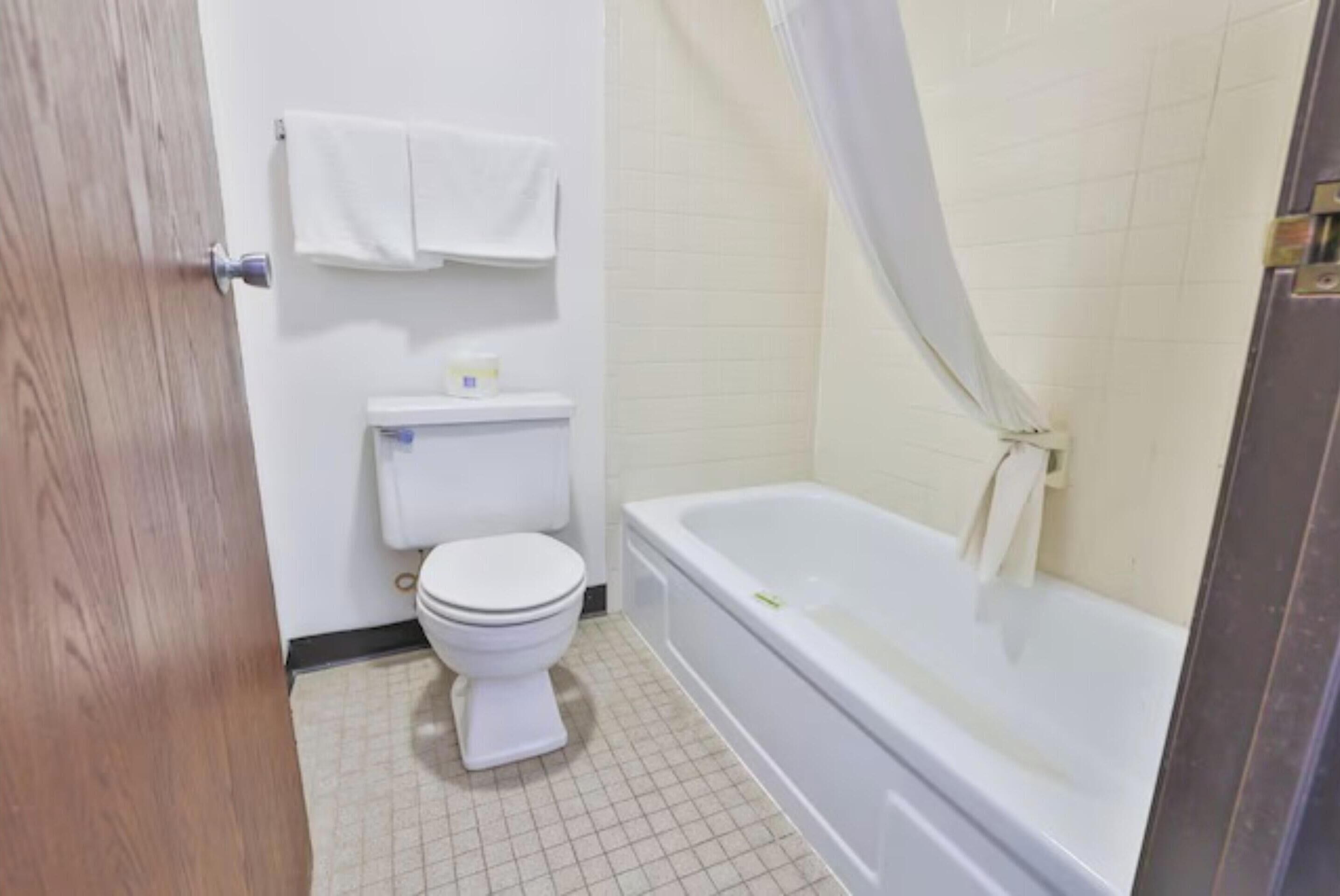 Ein Badezimmer mit Toilette, Badewanne und Duschvorhang.