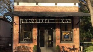 A brick building with a sign reading "COMFORT TEXAS". - Studio apartment with golf course view halfway between SA and Boerne (Boerne)