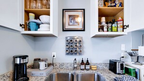 A kitchen with granite countertops, a double sink, a coffee maker, a toaster, and a spice rack. - Studio apartment with golf course view halfway between SA and Boerne (Boerne)