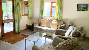 A living room with a sofa, armchairs, a glass coffee table, and a small side table. - Chestnut Lodge - UK38194 (Bromham)