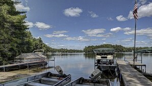 A dock with several boats, a covered area, and an American flag.