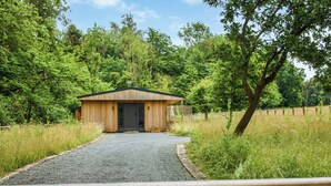 A wooden cabin with a gravel path leading to it, surrounded by greenery. - 1 bedroom accommodation in Chiddingstone (Chiddingstone)