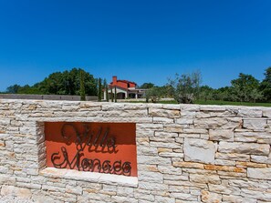 Un mur de pierre sur lequel est apposée une plaque indiquant « Villa Monaco ».