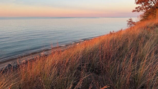 Ett kustlandskap med utsikt över havet och en gräsklädd kulle.
