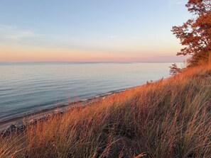 A coastal landscape with a view of the sea and a grassy hill.