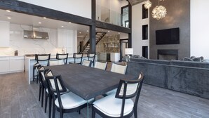 A modern interior with a dining area, kitchen, and living space. - Big Sky Luxury Estate, Mountain Views, 6 Bed 6.5 Bath, Private Lodge, Ski in/out (Big Sky)