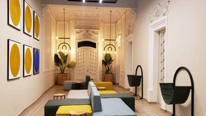 Un vestíbulo moderno con una zona de estar central, una entrada imponente y una escalera que conduce a los pisos superiores.