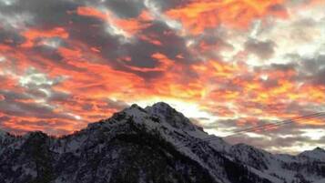 A snow-covered mountain range with a sunset sky.