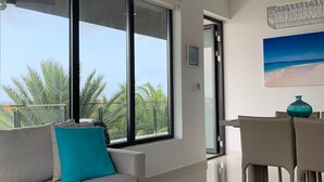 Un soggiorno moderno con un divano, un tavolino rotondo e un'area da pranzo con sedie.
