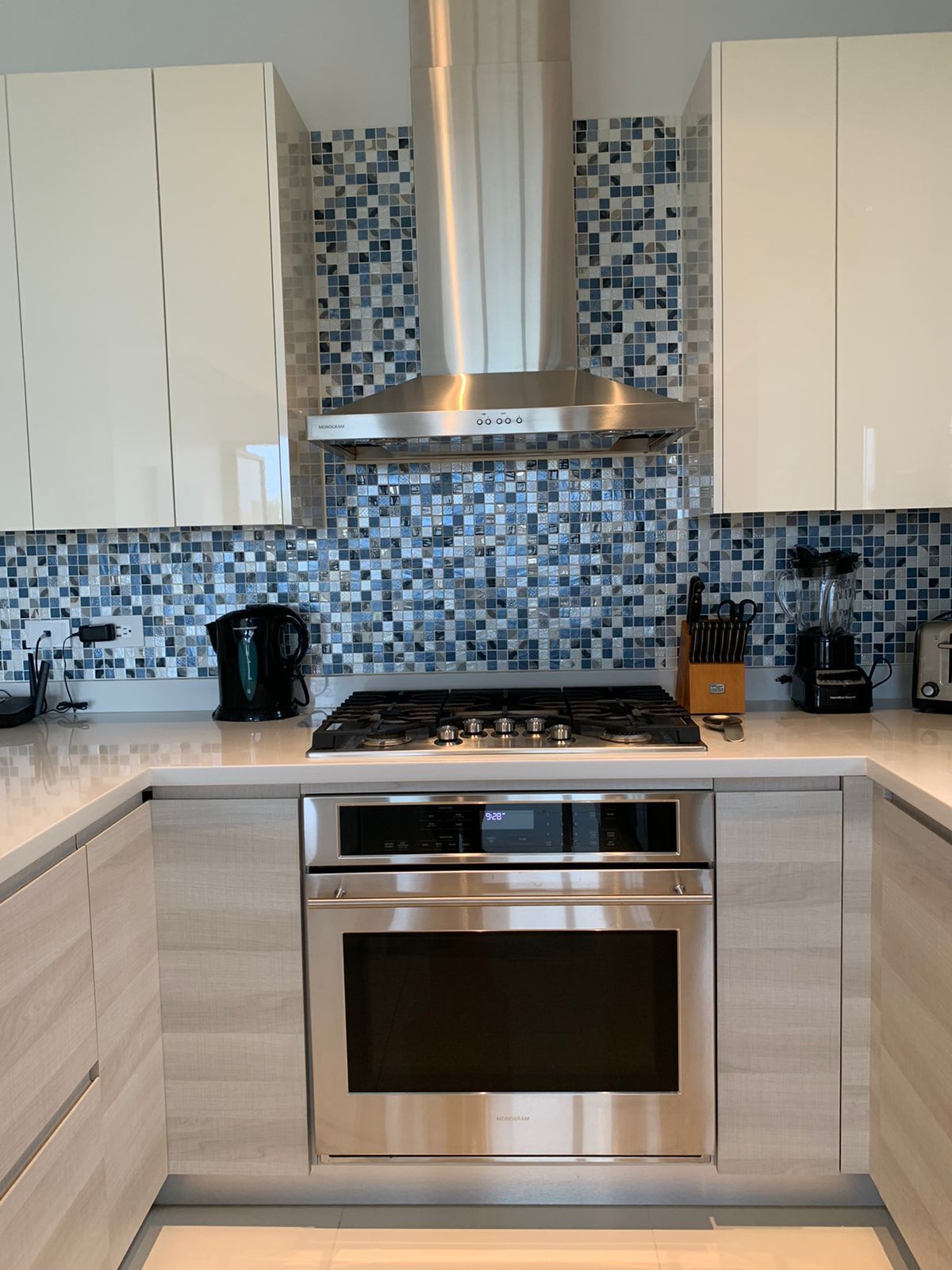 Een moderne keuken met roestvrijstalen apparatuur, een betegelde spatwand en lichte kasten.